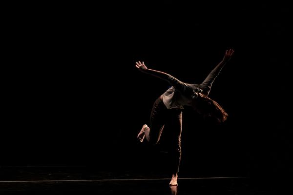 An image of a dancer tossing their head forward, mid-step.
